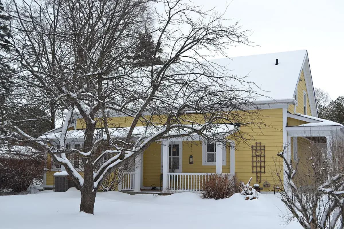 Maison jaune sous la neige, au Québec