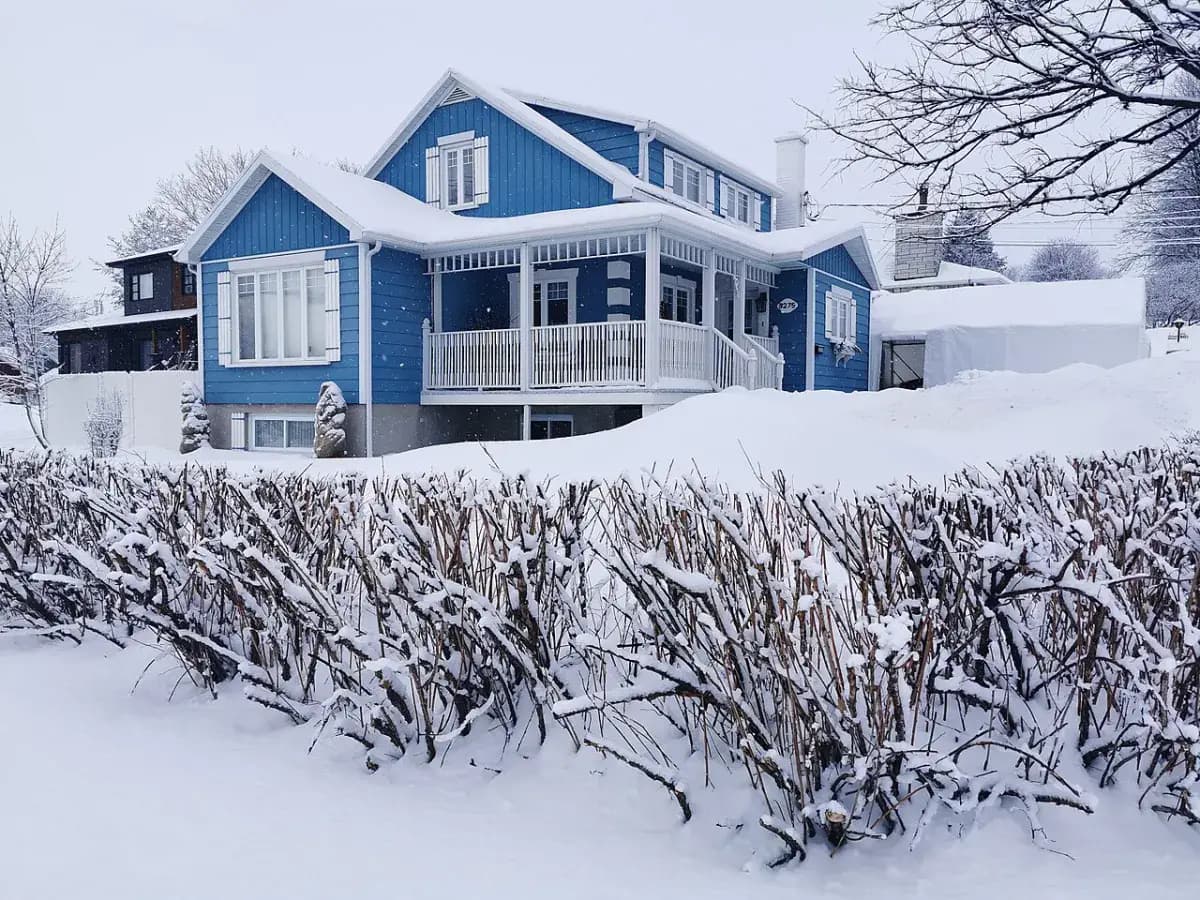Maison bleue après une chute de neige, au Québec
