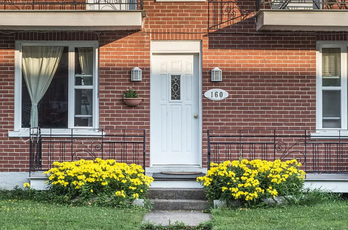 Entrée d’une maison de brique fleurie, au Québec